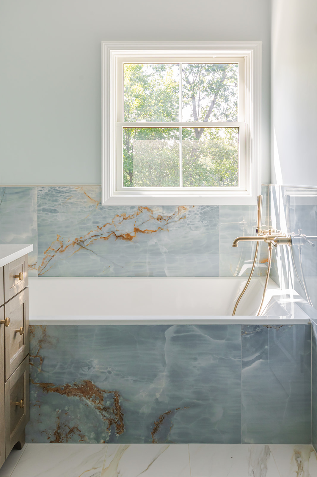 Scherr bathroom remodel with marble-surround tub and brass fixtures