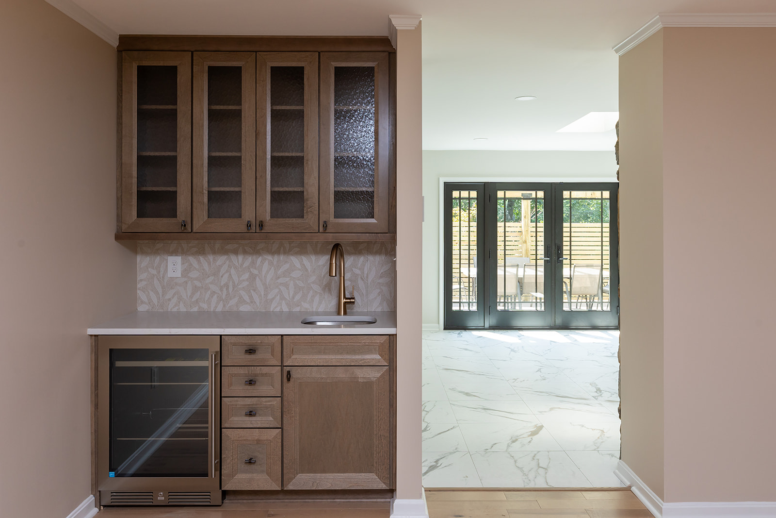 Scherr whole-home remodel with custom wet bar and marble-tiled living space beyond