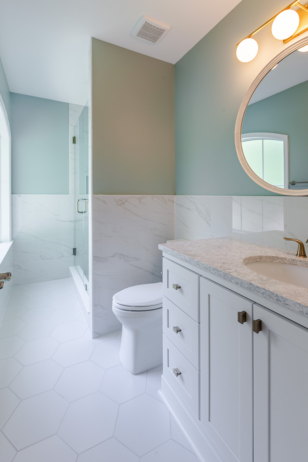 Scherr bathroom remodel with white vanity, hexagon tile floor, and glass shower