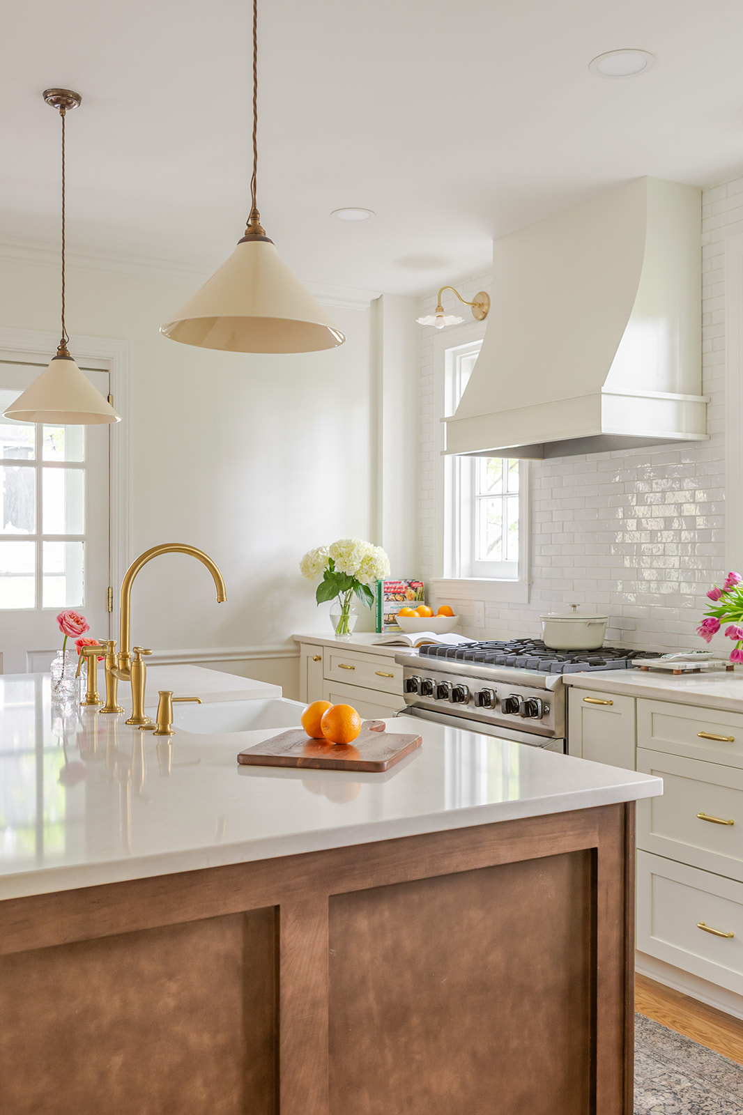 Scherr kitchen remodel with cream cabinetry, brass fixtures, and plaster hood