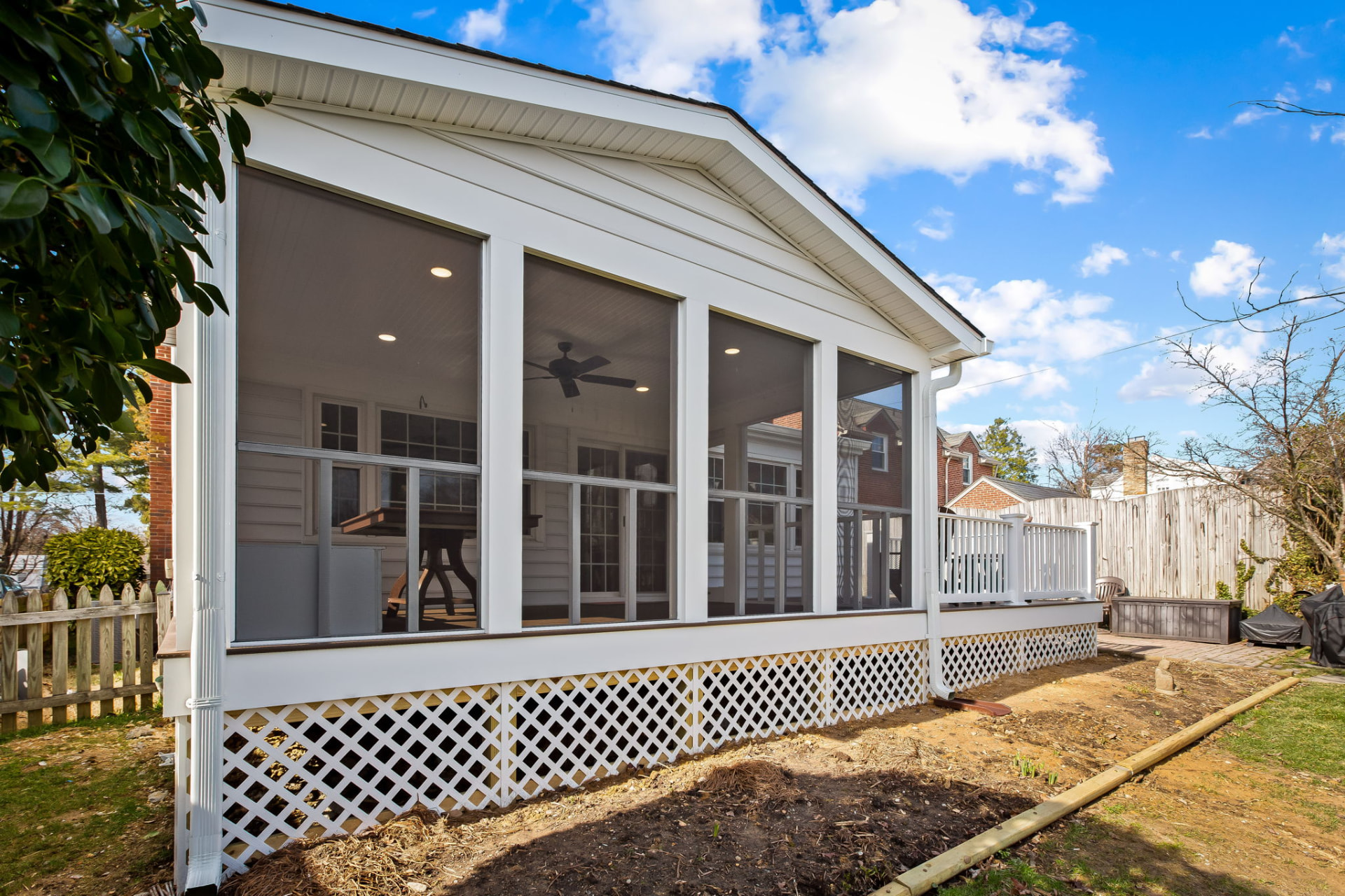 Scherr screened porch addition exterior with white trim and lattice skirt